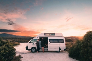 Postkarte von einem weißen Campervan im Sonnenuntergang in der Bay of Fires, Tasmanien.