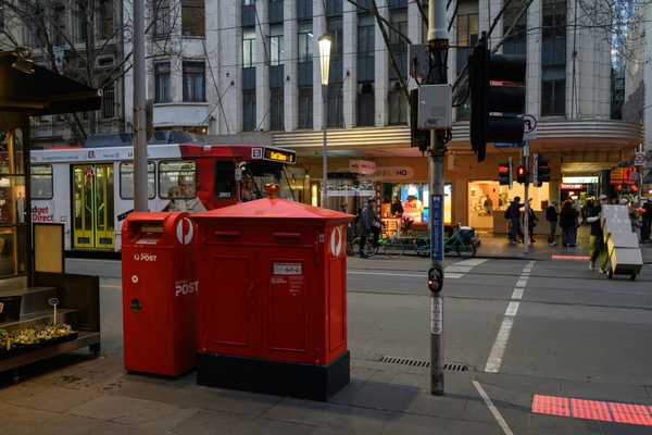 Ein klassischer roter Briefkasten der Australia Post auf dem Gehweg.
