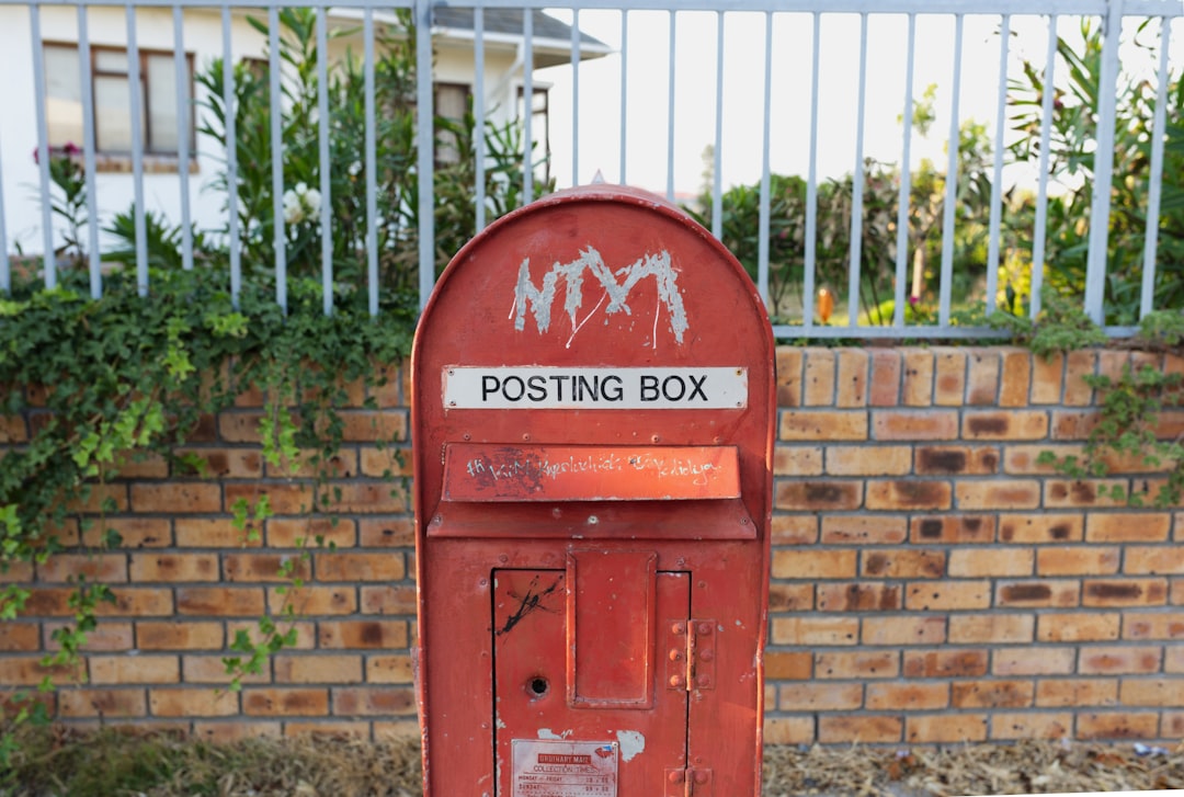 Boîte aux lettres rouge sur un mur de briques