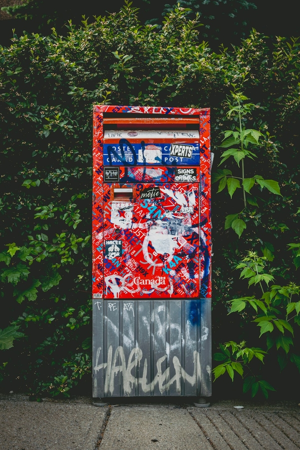 Une boîte aux lettres de Canada Post couverte de graffitis