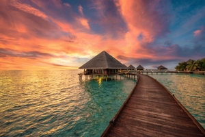 Carte postale montrant des bungalows sur pilotis au coucher du soleil