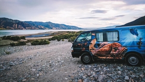 Van noir sur un chemin de terre en Nouvelle-Zélande – road trip typique à travers l'île du Nord.