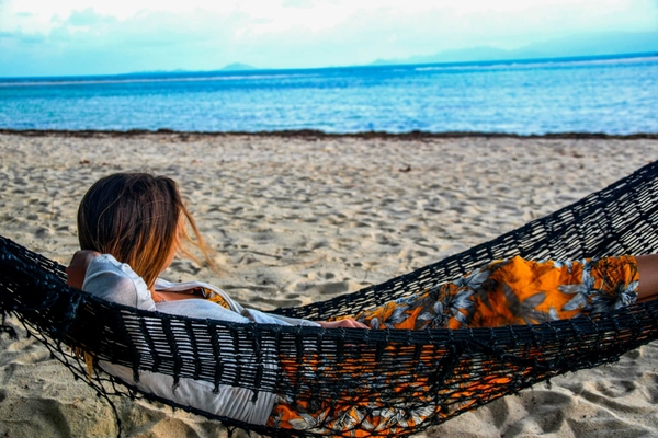 Quelqu'un allongé dans un hamac sur la plage.