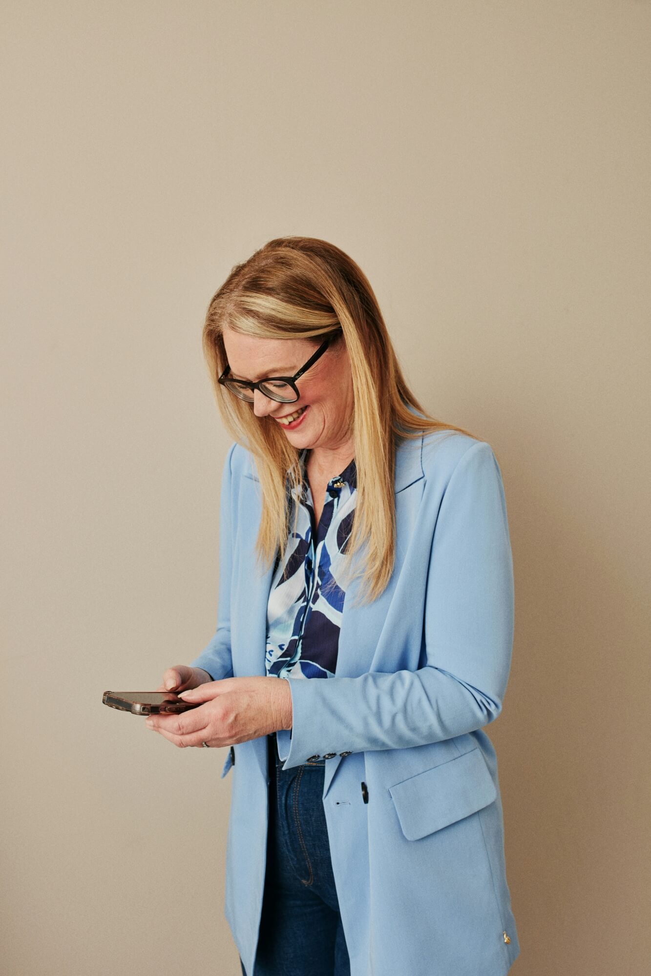 Mutter lächelt beim Blick auf ihr Smartphone