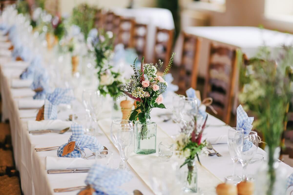 Table de mariage festivement dressée dans une lumière chaude avec des verres à vin et des fleurs