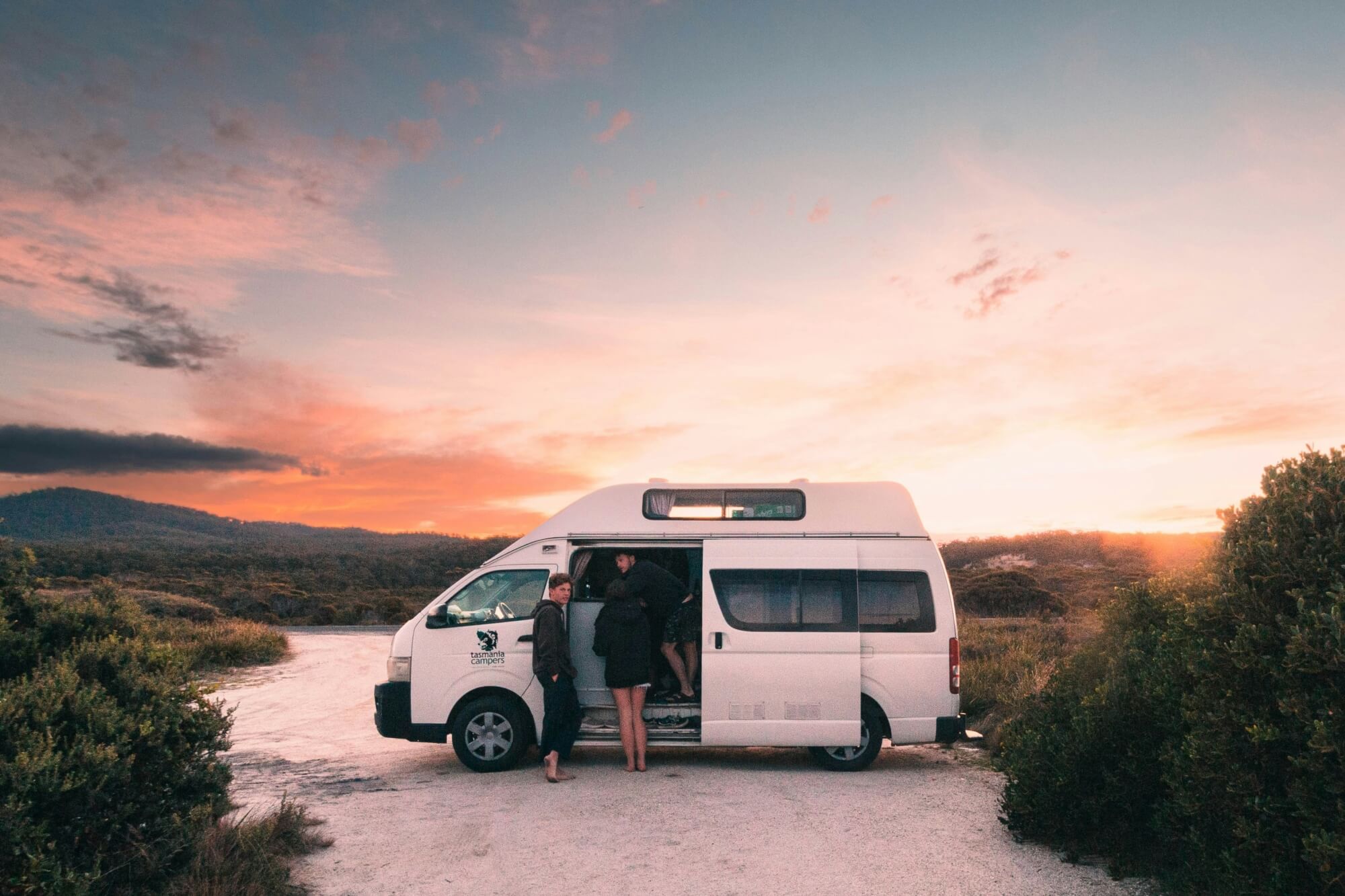 Postkarte von einem weißen Campervan im Sonnenuntergang in der Bay of Fires, Tasmanien.