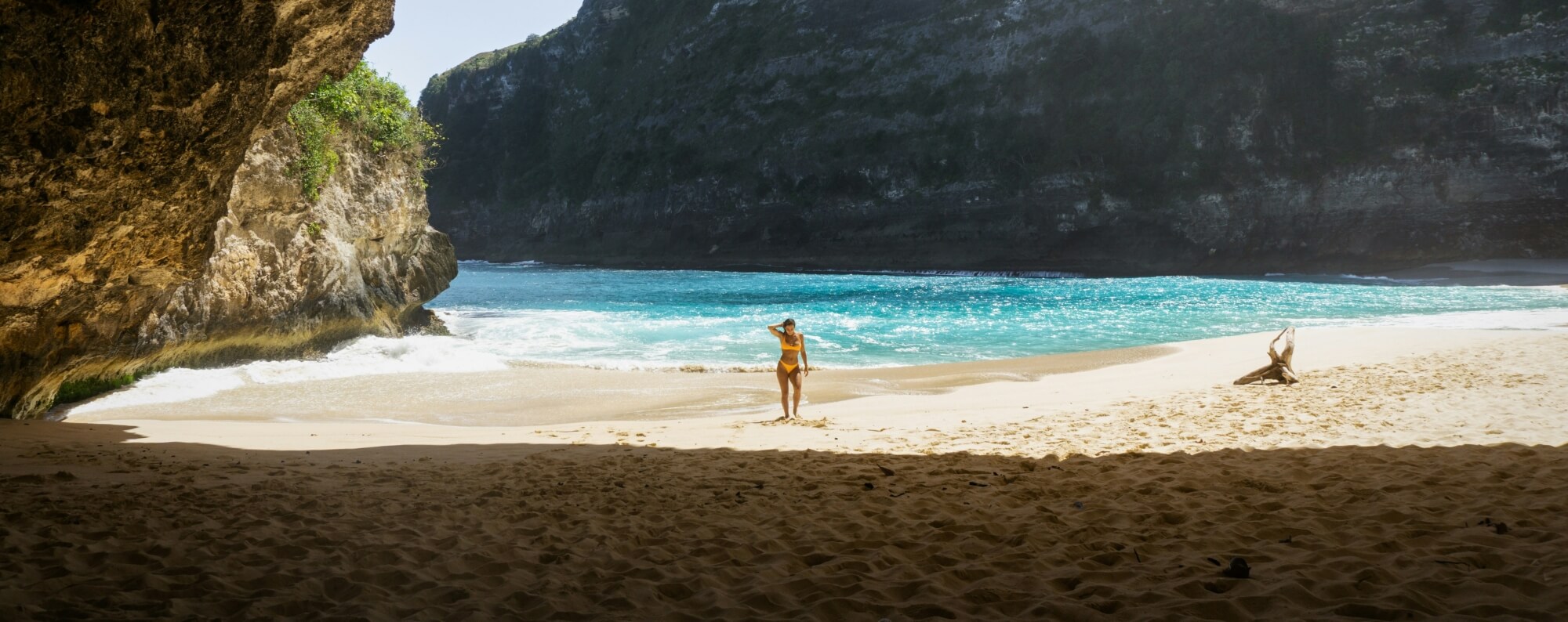 Ein Mädchen im Bikini steht an einem sonnigen Tag am wunderschönen Kelingking Beach Nusa Penida Bali Indonesien.