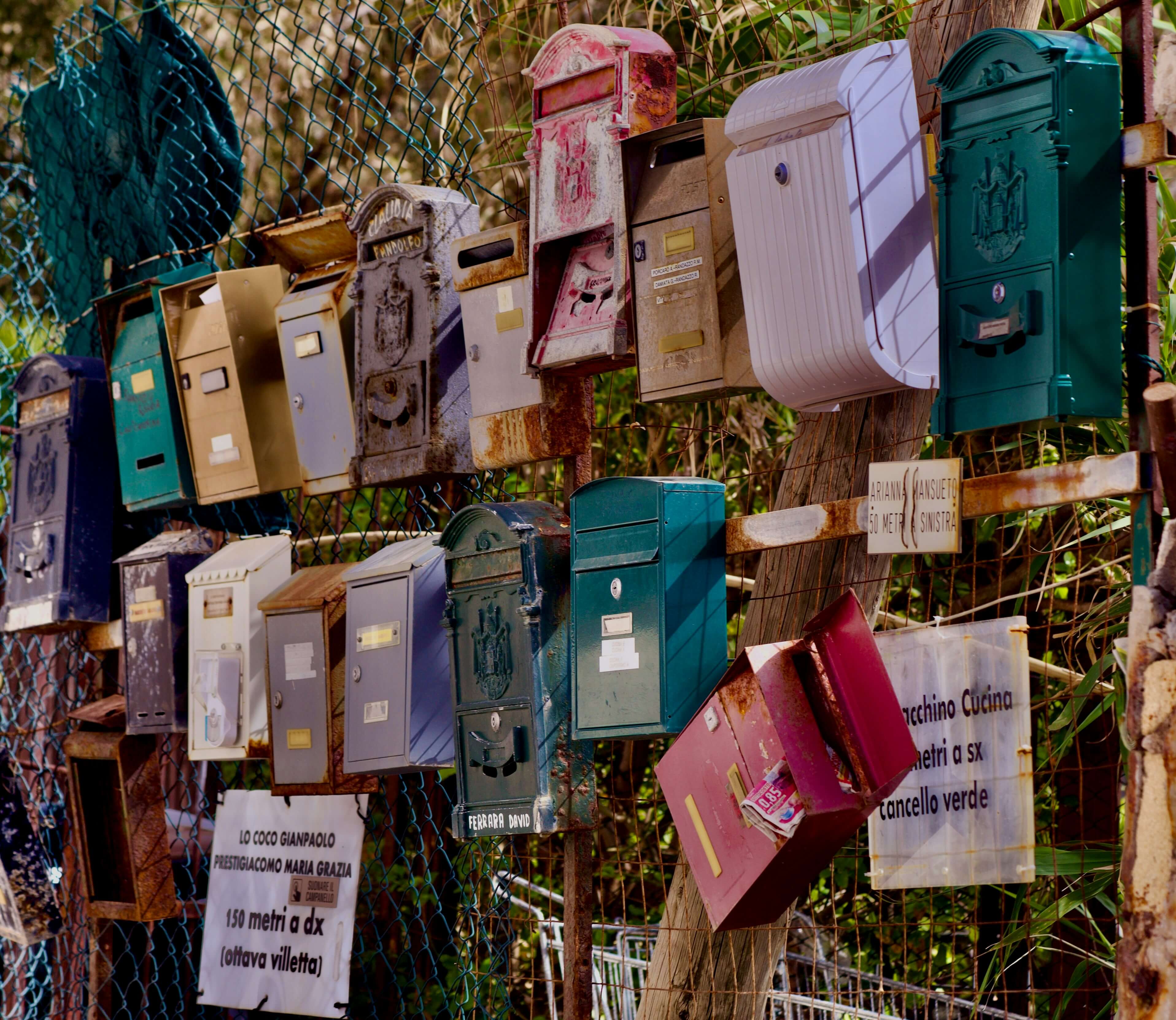 Mehrere private und veraltete Briefkästen nebeneinander in Italien