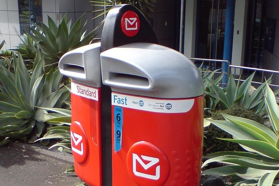 Roter Briefkasten der New Zealand Post in einer neuseeländischen Stadt.