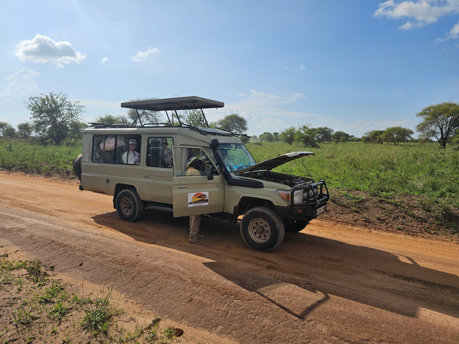 Broken down car in the Serengeti with an open hood